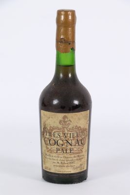 une vieille bouteille de vin posée sur une surface blanche