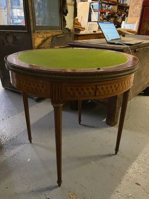 une petite table au plateau vert dans une pièce