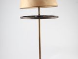 a black lamp with a tan shade on top of it