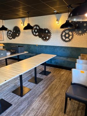 une longue table au milieu d'une pièce, entourée de plusieurs chaises