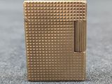 a close up of a gold lighter sitting on top of a table