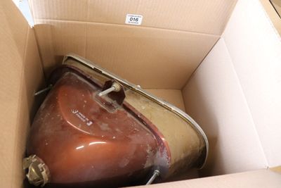 une valise marron dans un carton sur lequel est accrochée une étiquette