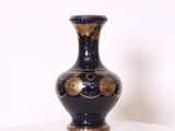 un vase bleu posé sur une étagère blanche