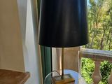 une table en verre sur laquelle est posée une lampe, devant une fenêtre