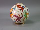 a white vase with colorful designs on it on a table