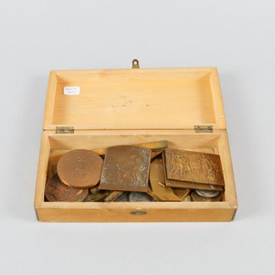 une boîte en bois remplie de pièces de monnaie de différentes sortes