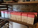 several boxes of wine are stacked on a wooden shelf in a room