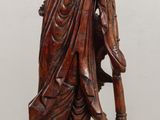 carved wooden statue of a man with a hat and a cane