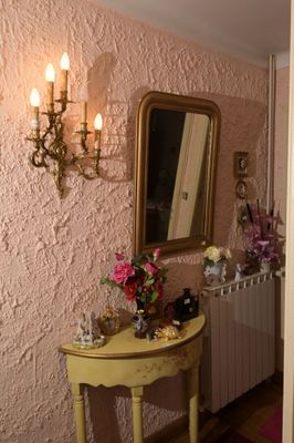 une petite table sur laquelle se trouvent un miroir et un vase
