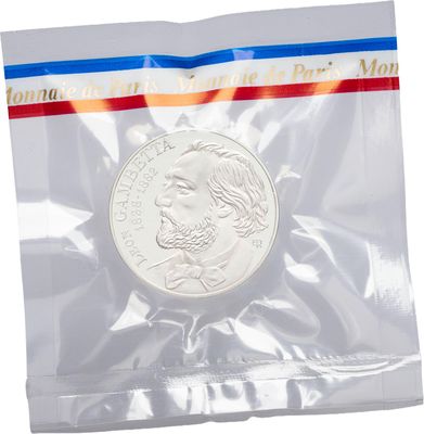 a close up of a coin in a plastic bag on a white background