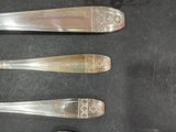 four spoons and a fork sitting on a table