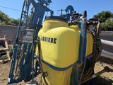 un char jaune posé par terre à côté d'une machine bleue