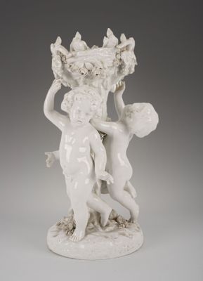une statue blanche représentant une femme tenant un panier de fleurs
