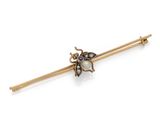 a close up of a gold and pearl insect broochle