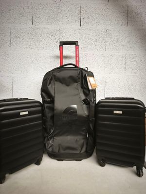 trois bagages posés les uns à côté des autres par terre
