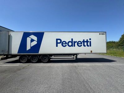 a white semi truck parked in a parking lot next to a building