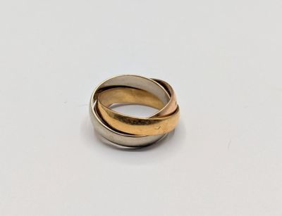 a close up of a gold and silver ring on a white surface