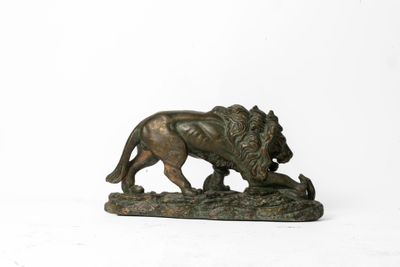 statue en bronze d'un lion sur un rocher sur fond blanc