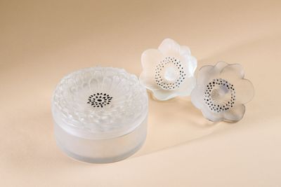 a white container with a flower inside of it on a table