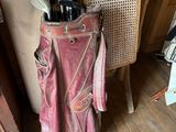 a bag of golf clubs sitting on a chair in a room
