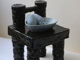 une petite chaise noire sur laquelle est posé un bol