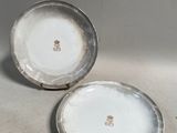 deux assiettes blanches à bordure argentée posées sur une table