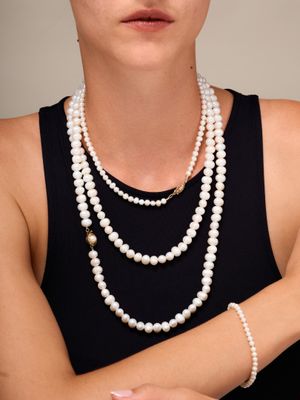 a woman that is wearing a necklace with pearls on it
