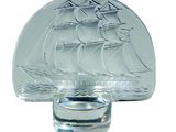 a glass bottle with a ship on it and a shot glass with a shot glass in front of it