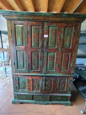 une très vieille armoire en bois au milieu d'une pièce