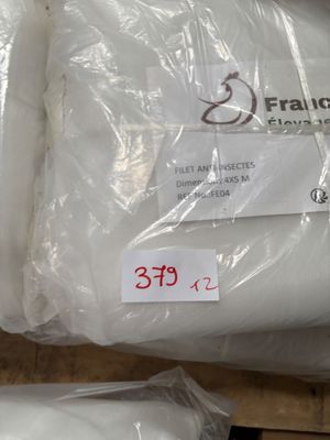 deux sacs contenant des oreillers blancs posés par terre, avec des étiquettes de prix