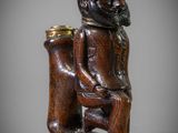 une figurine en bois représentant un homme avec un chapeau et une pipe