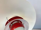 a red lamp that is on a white table