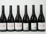 six bottles of wine are lined up in a row on a table