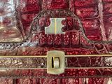 a close up of a red purse with a metal handle