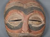 une image représentant un masque en bois sur fond gris