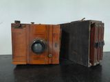 two old wooden cameras sitting on a black table