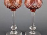 two wine glasses sitting next to each other on top of a table