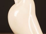 a white bird that is sitting on a wooden table