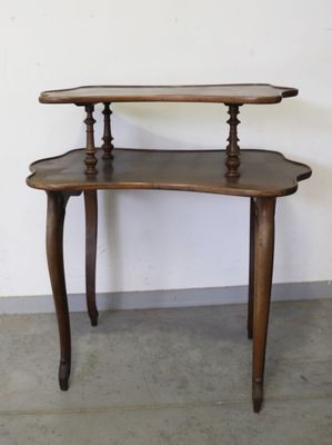une petite table en bois surmontée de deux étagères