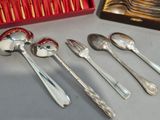five silver spoons and two silver spoons in a red box