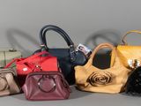 several purses are lined up in a row on a gray surface