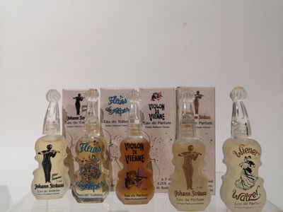Des flacons de parfums aux arômes variés sont alignés sur une étagère