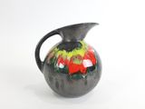 un vase noir orné d'un motif rouge et vert