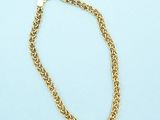 a close up of a gold chain bracelet on a blue background