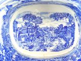 a blue and white plate with a landscape on it