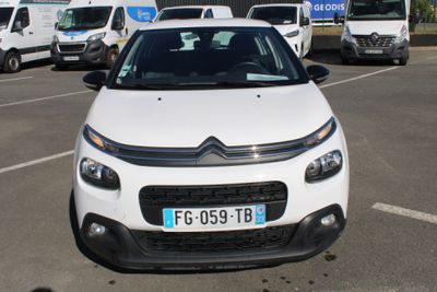 une petite voiture blanche garée dans un parking