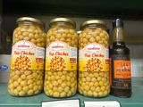 Des bocaux de pois chiches marinés et une bouteille de bière sont posés sur une étagère