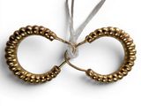 an image of a pair of gold rings hanging from a string