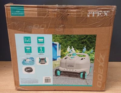 packaging of a robotic lawn mower in a cardboard box on a table