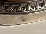 a close up of a silver plate with a clock on it